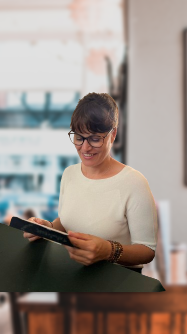 Aurélie le Blanc énergéticienne: assise regardant une tablette pour la prise de contact