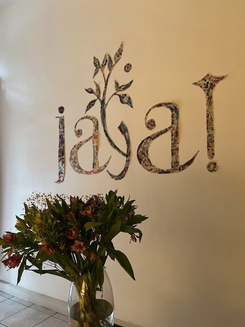 Espace Jaya écrit au mur avec un bouquet de fleurs